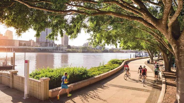 Cyclists and a runner on the Brisbane riverside path